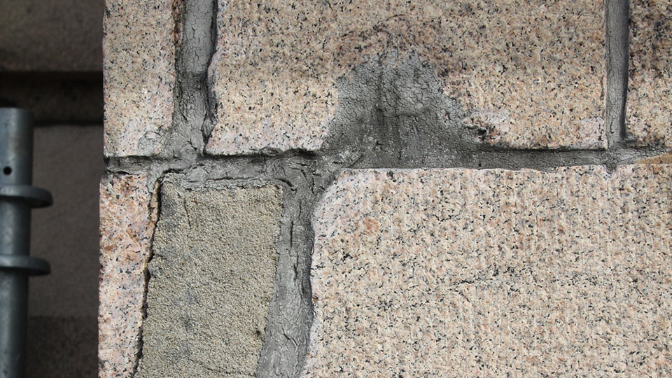 Damage to the pink granite façade of the Travelers Tower required masonry repairs. Depending on the severity of the cracks, the stones were either repinned with stainless steel anchors, or epoxy injections and mortar were used to patch the cracks, so they were no longer visible.