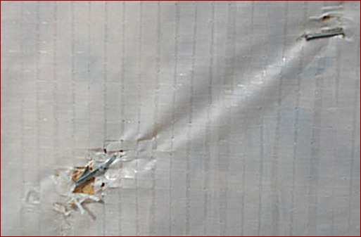 Wind-related movement has caused holes in this fabric wrap air barrier. The holes will compromise the air barrier’s performance by letting air pass through, even though the air’s route to the hole from inside the building may be indirect and convoluted.