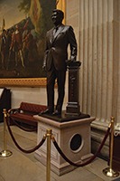 Shown is a bronze statue of President Ronald Reagan; the pedestal includes a band of concrete pieces from the Berlin Wall. 