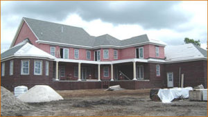 Rain clouds over this partially completed luxury residence in Myrtle Beach, S.C., underscore the importance of air barriers that are durable enough to act as secondary drainage planes. Though the masonry veneer isn't yet up on the second story, the walls are protected by a water-based, fluid-applied air- and water-resistive barrier. Photo courtesy of PROSOCO